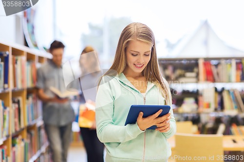 Image of happy student girl with tablet pc in library