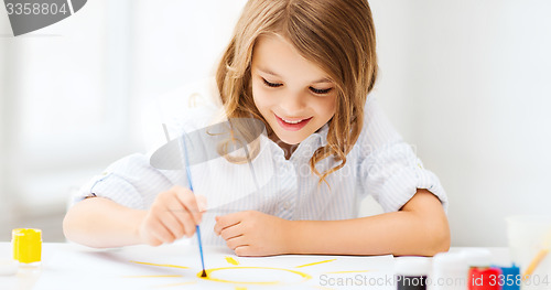 Image of little girl painting at school