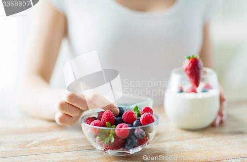 Image of close up of woman hands with yogurt and berries