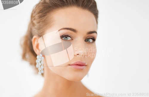 Image of woman wearing shiny diamond earrings