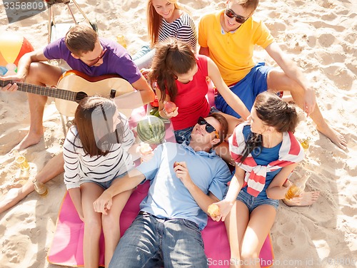 Image of group of happy friends having fun on beach