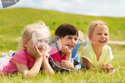 Image of group of kids lying on blanket or cover outdoors