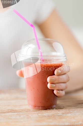 Image of close up of woman holding cup with smoothie