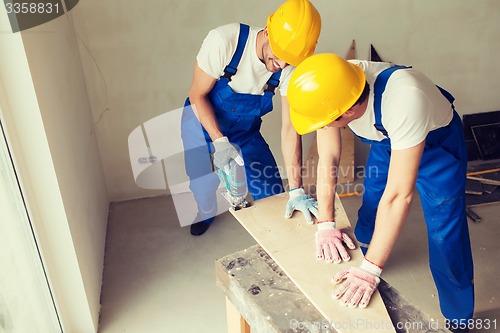 Image of group of builders with tools indoors