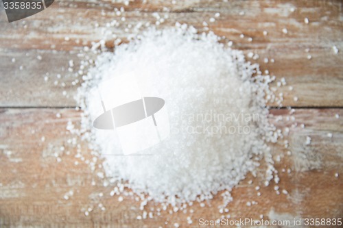 Image of close up of white salt heap on wooden table