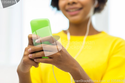 Image of happy african woman with smartphone and headphones