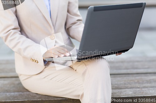 Image of close up of business woman with laptop in city