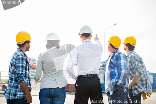 Image of group of builders and architects at building site