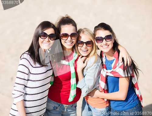 Image of happy teenage girls or young women on beach