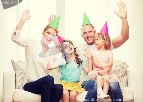 Image of happy family with two kids in hats celebrating