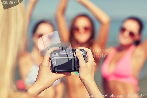 Image of close up of smiling women photographing on beach