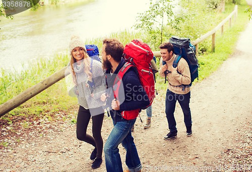 Image of group of smiling friends with backpacks hiking