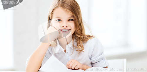 Image of little student girl studying at school