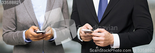 Image of businessman and businesswoman with smartphones