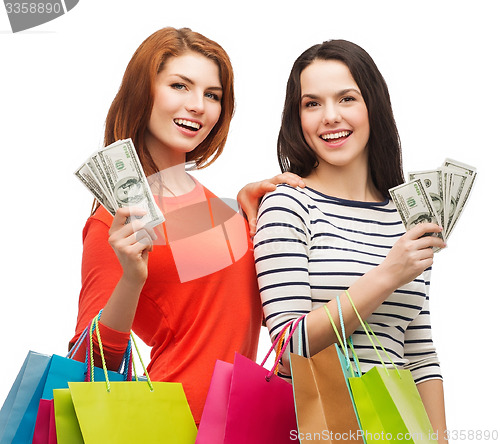 Image of smiling teenage girls with shopping bags and money