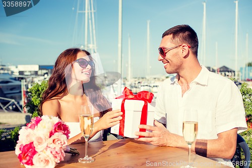 Image of smiling couple with gift box cafe