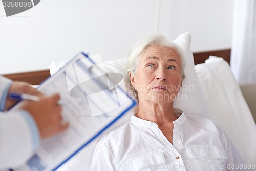 Image of doctor visiting senior woman patient at hospital