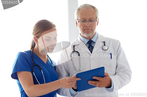 Image of senior doctor and nurse with tablet pc at hospital