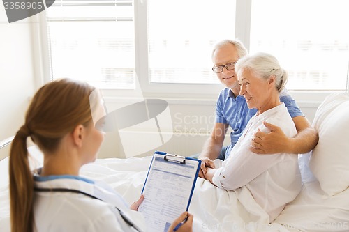 Image of senior woman and doctor with clipboard at hospital