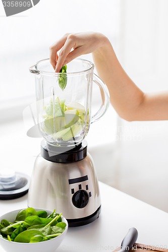 Image of close up of woman hand with blender and vegetables