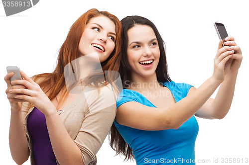 Image of two smiling teenagers with smartphones