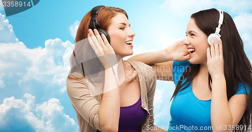 Image of two happy girls with headphones listening to music