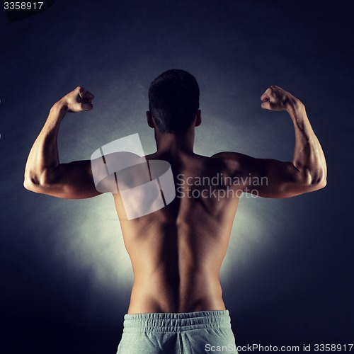 Image of young man showing biceps