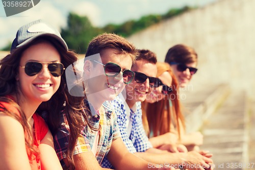 Image of close up of smiling friends sitting on city street