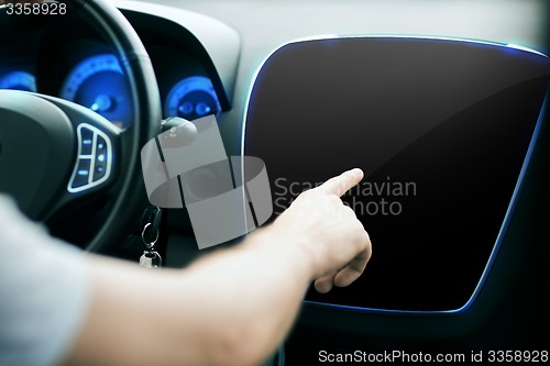 Image of male hand pointing finger to monitor on car panel