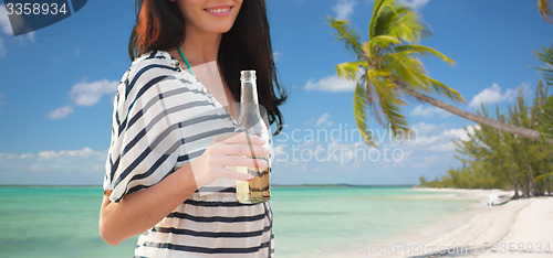 Image of close up of smiling young woman drinking on beach