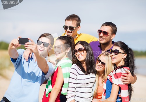 Image of group of friends taking selfie with cell phone