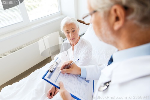 Image of senior woman and doctor with clipboard at hospital