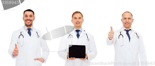 Image of happy doctors with tablet pc showing thumbs up