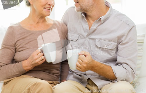 Image of close up of happy senior couple with cups at home
