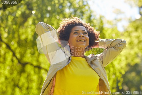 Image of happy african american young woman in summer park