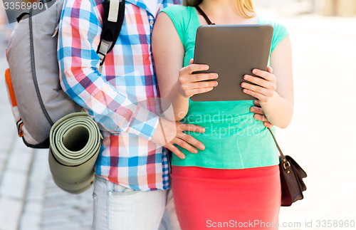 Image of couple with tablet pc and backpack in city