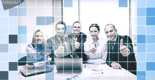 Image of business team showing thumbs up in office