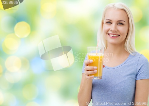 Image of smiling woman drinking orange juice