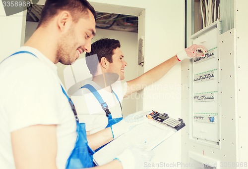 Image of builders with clipboard and electrical panel