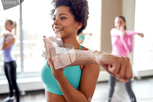 Image of group of smiling people dancing in gym or studio