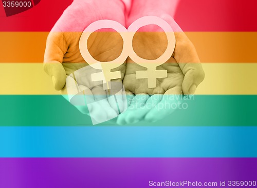Image of close up of lesbian couple hands with venus symbol