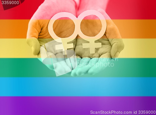 Image of close up of lesbian couple hands with venus symbol