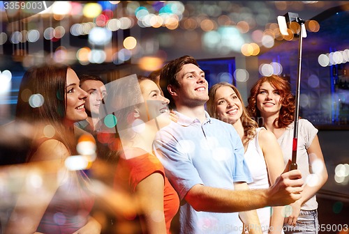 Image of friends with smartphone taking selfie in club