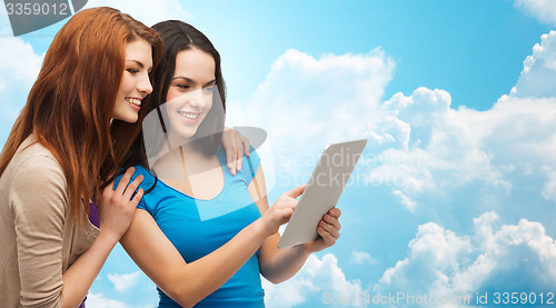 Image of two smiling teenagers with tablet pc computer