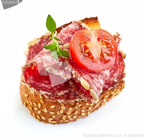 Image of toasted bread with salami and tomato