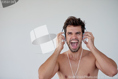 Image of handsome young man listening music on headphones