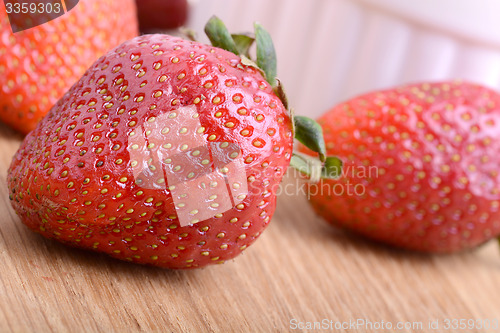 Image of Strawberry set on wooden plate close up