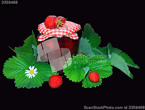 Image of jar with strawberry jam and green leaves