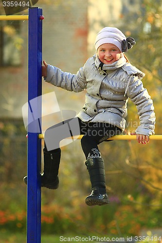 Image of blue-eyed girl on the horizontal bar