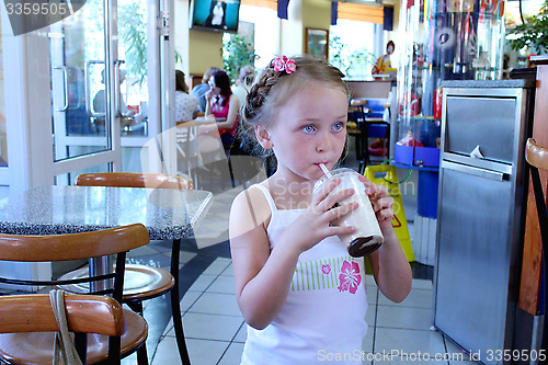 Image of beautiful girl having dinner in cafe